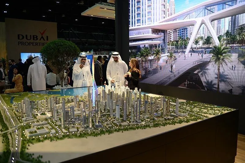 Visitors exploring a model at the Dubai Property Show in Sydney showcasing futuristic real estate developments.
