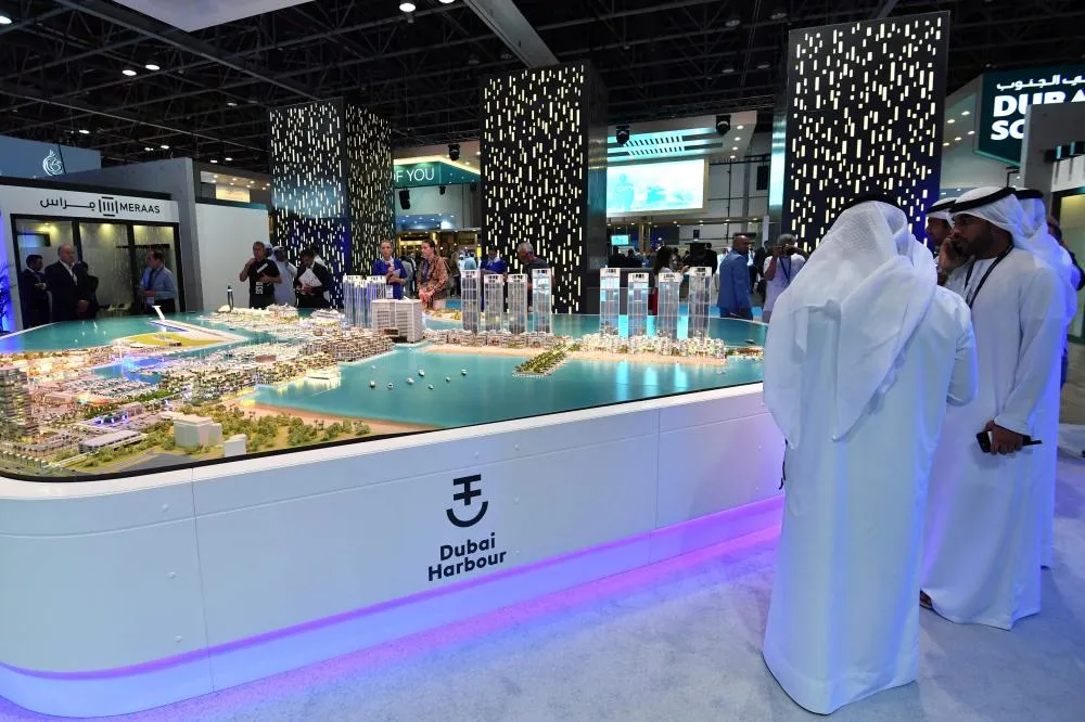 Participants admiring the Dubai real estate model at the Dubai Property Show in Sydney, including Burj Khalifa and luxury buildings.